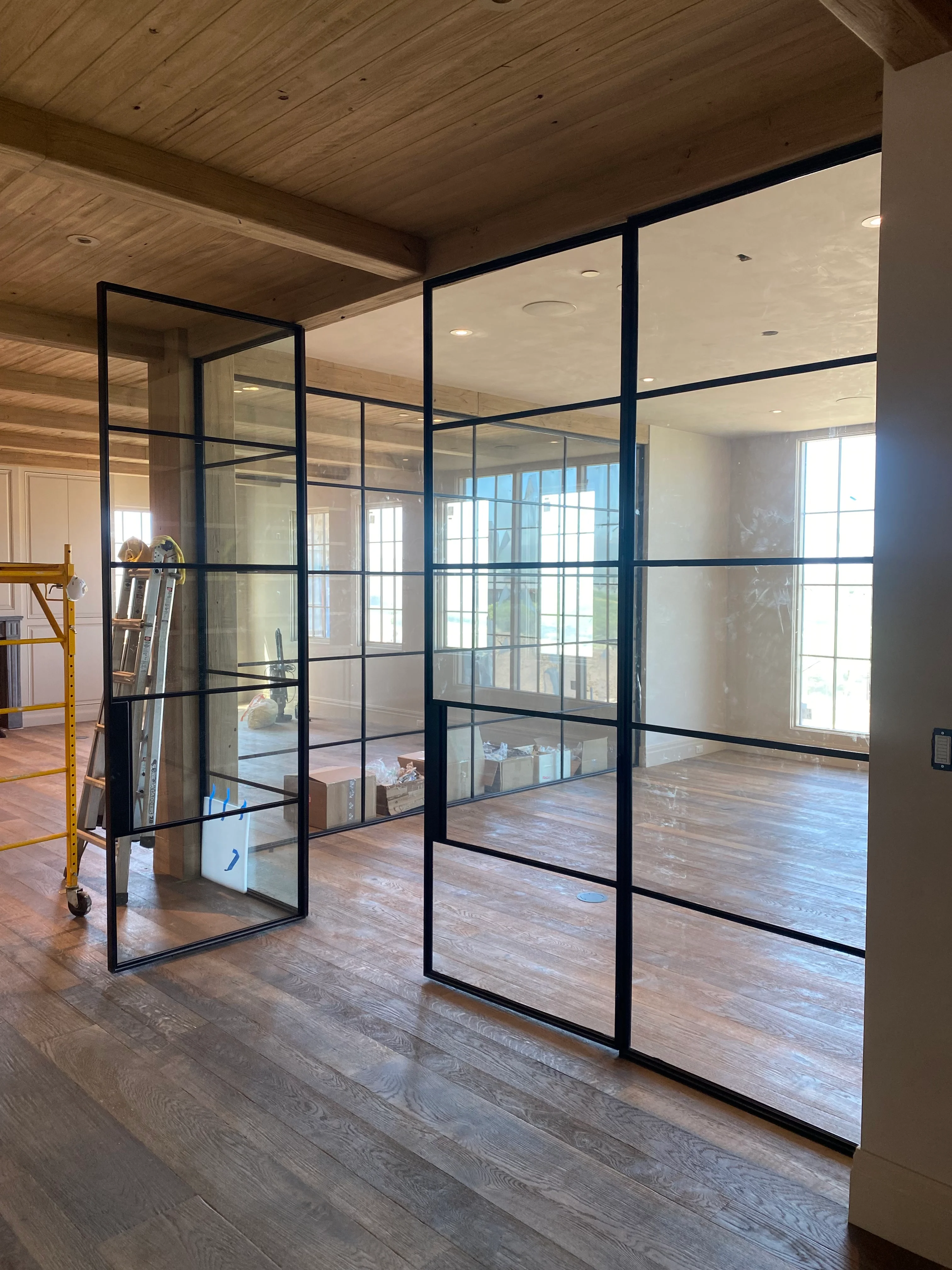 Black-framed glass partition wall with gridded panels in modern commercial interior
