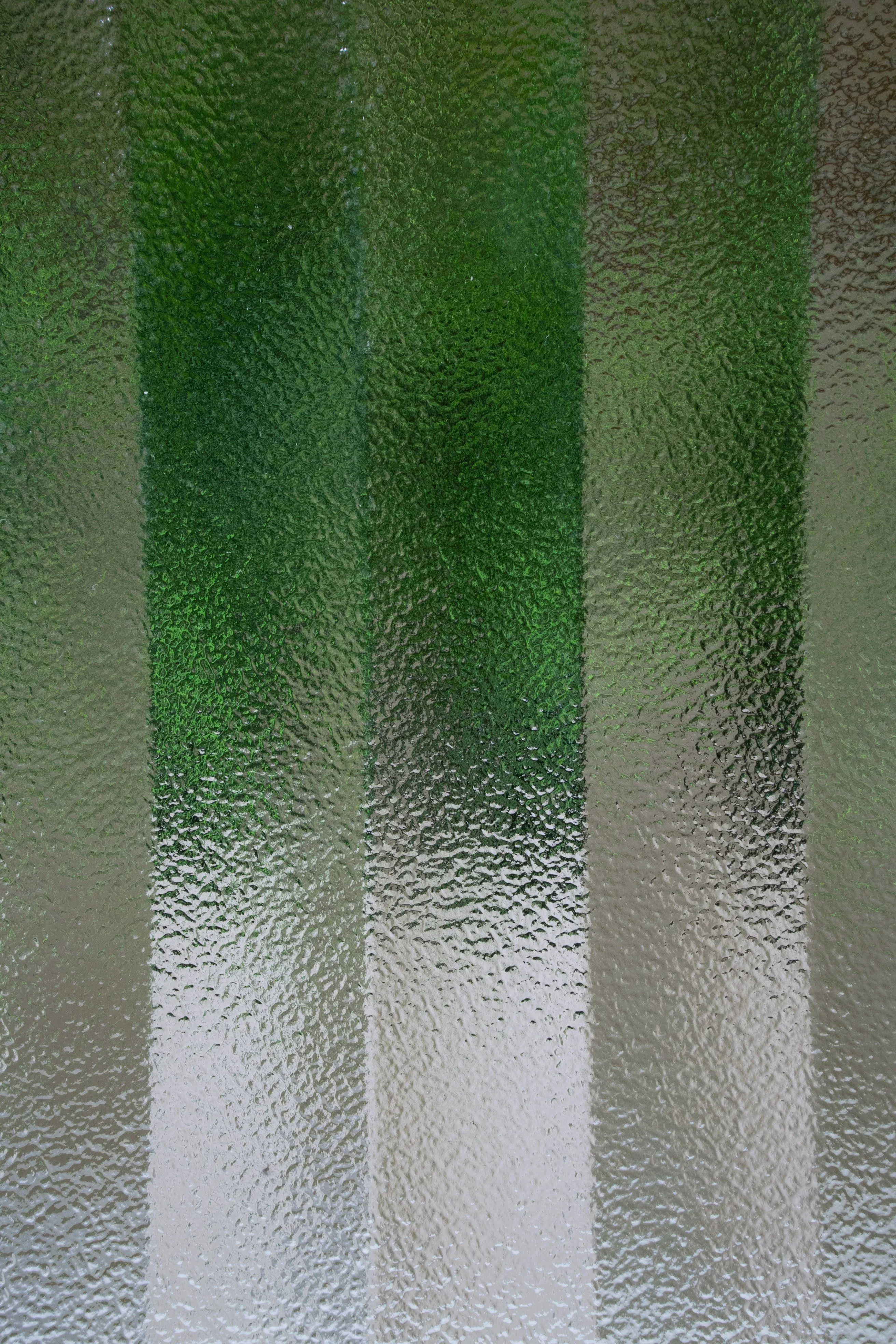 Textured glass panels with green-to-white gradient finish showing decorative surface treatment