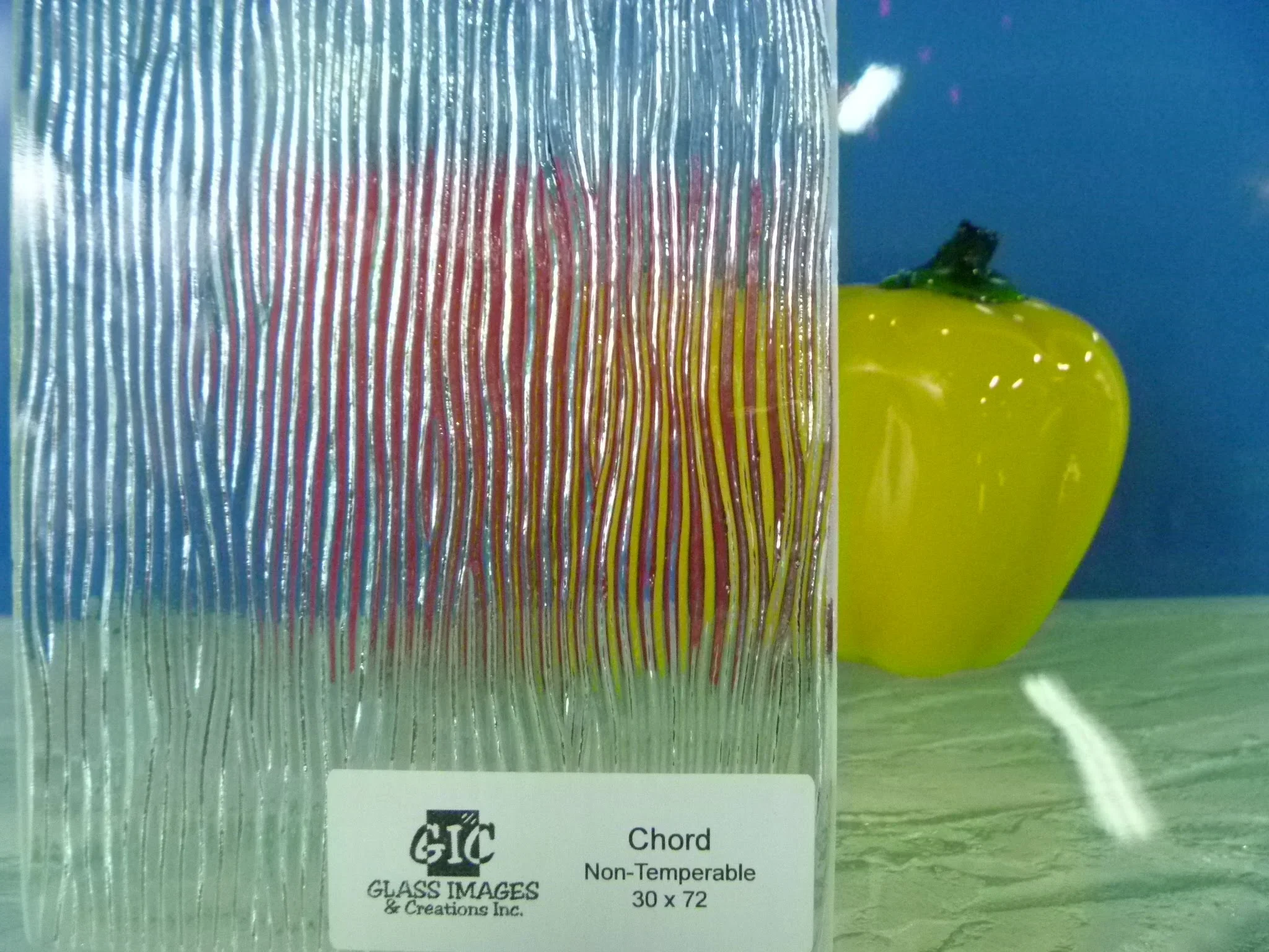 Decorative glass panel with vertical chord pattern and red-to-yellow color gradient