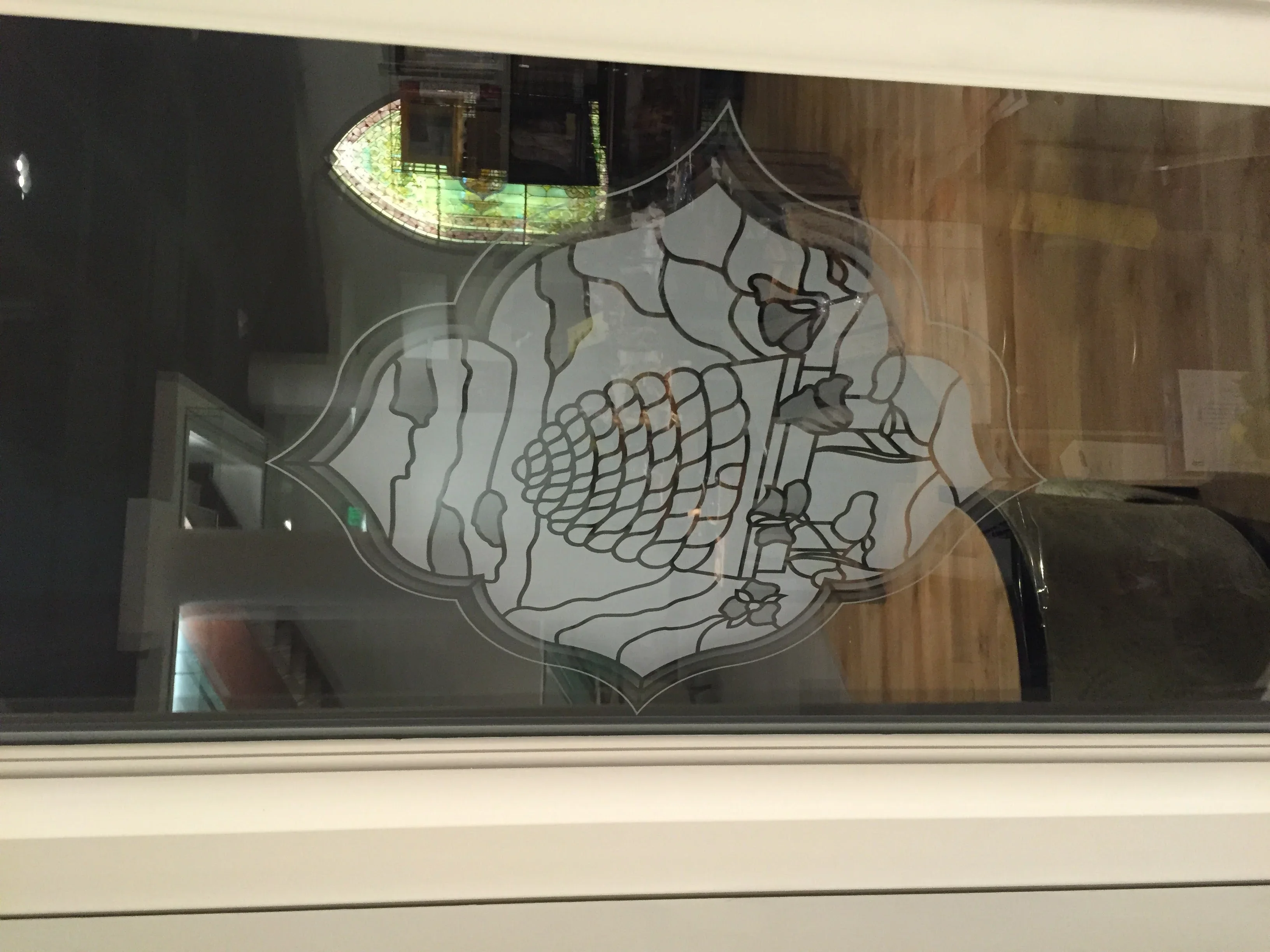 Etched glass panel with ornate decorative design featuring anatomical and botanical line work