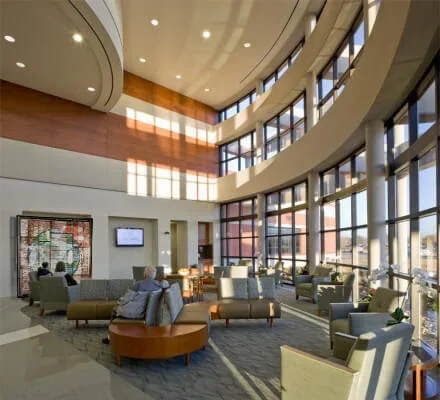 Modern commercial lobby with curved glass wall system and abundant natural lighting