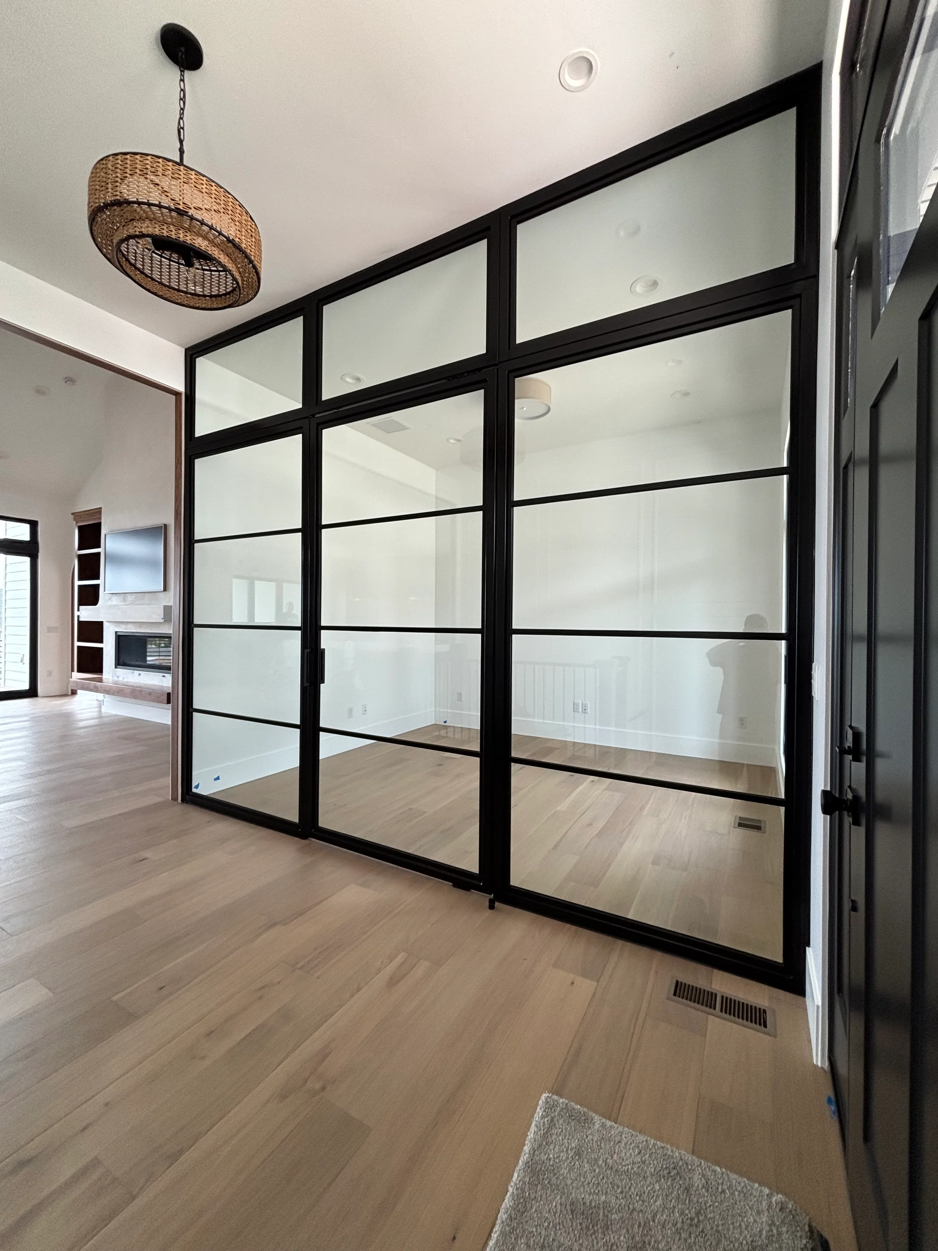 Black-framed glass partition with mirrored panels in modern home interior