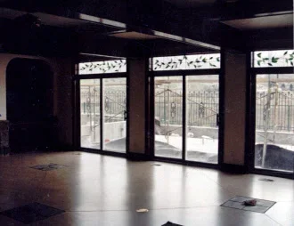 Commercial glass storefront with multiple aluminum-framed doors and frosted transom windows