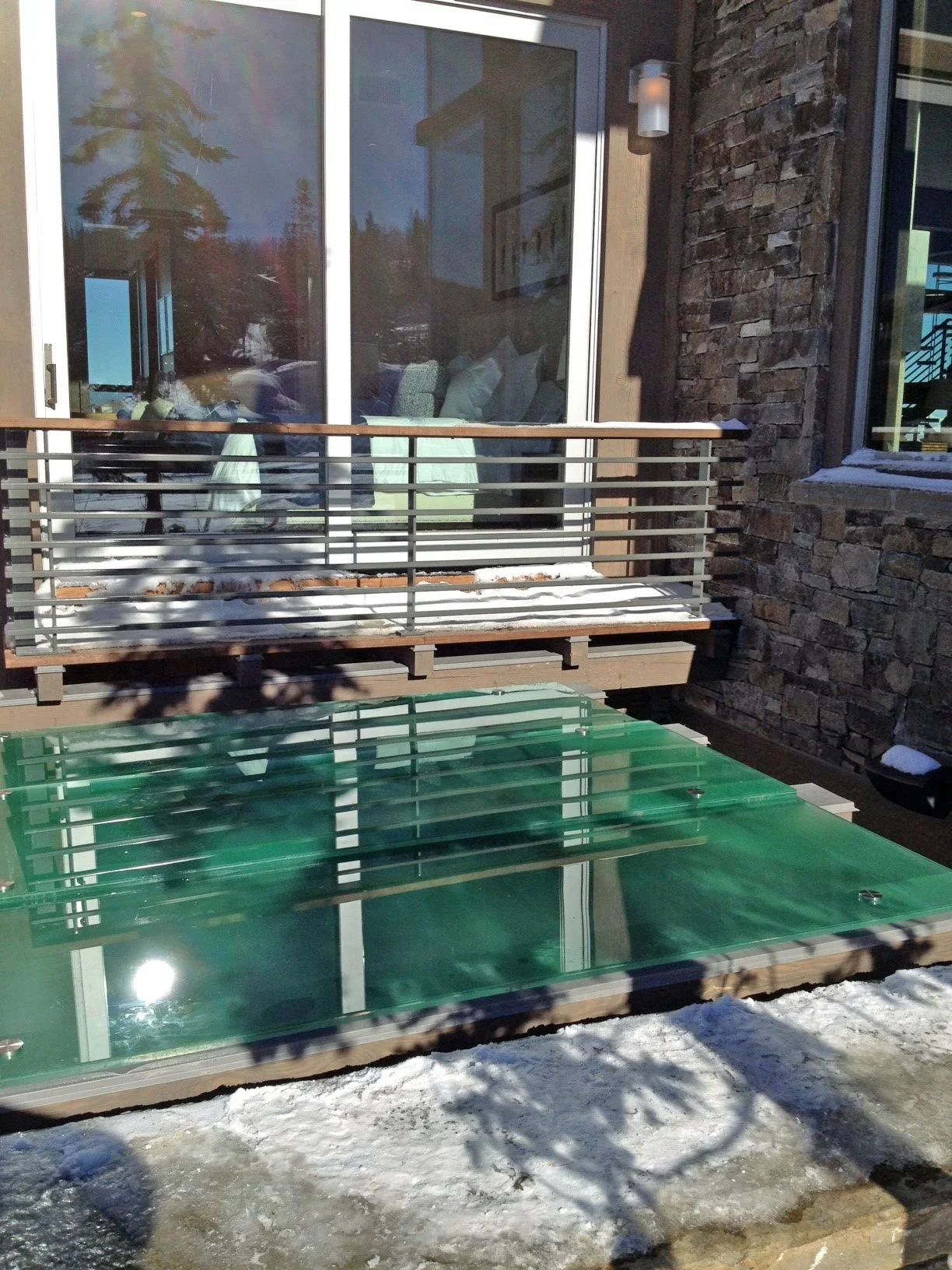 Glass railing balcony with aluminum frame overlooking snowy mountain landscape
